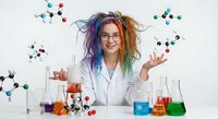 Young female scientist with colorful hair in lab coat conducting chemistry experiments with molecular models and colorful solutions in laboratory.