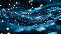 Glowing particles float over dark blue waves creating magical atmosphere with bokeh light effects and sparkles. Abstract macro photography for dreamy backgrounds.