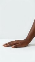 Close-up of an extended arm and hand with medium-dark skin tone against neutral background, suitable for healthcare, wellness, and beauty product marketing.