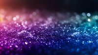 Magical glitter sparkles in purple and blue gradient colors with bokeh effect on dark background, abstract festive texture with defocused lights.