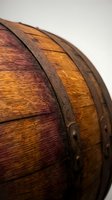 Vintage wooden barrel with rich grain texture and metal bands showing traditional craftsmanship and rustic charm for brewing or storage applications.