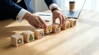 Businessman arranging wooden blocks with icons in sequence on desk, representing business strategy, growth planning, and organizational workflow for corporate development concepts.