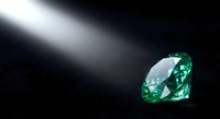 Brilliant green emerald gemstone with dramatic lighting on dark background for luxury jewelry and precious stone designs.