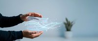 Business professional hands protecting glowing digital network connections with data flow visualization in modern office environment for technology concepts.