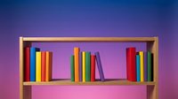 Wooden bookshelf with colorful books arranged on shelves against vibrant purple and pink gradient background, suitable for education, library, and learning concepts.
