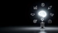 Glowing lightbulb with brain inside surrounded by business icons on dark background representing innovation, creativity and entrepreneurship concepts.