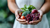 Fresh organic vegetables and fruits in cupped hands including broccoli, tomatoes, radish and berries promoting healthy eating and nutrition lifestyle.