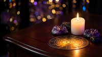 Mystical altar setup with burning candle, amethyst crystals and golden pentagram circle on wooden table with bokeh lights background for spiritual rituals.