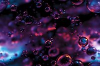 Ethereal water drops floating in cosmic purple and blue atmosphere with glowing red highlights create dreamy abstract macro background for creative projects.