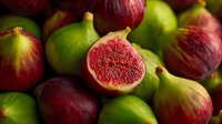 Fresh ripe figs collection with cut half showing pink flesh, green and purple varieties mixed together for healthy eating and Mediterranean cuisine.