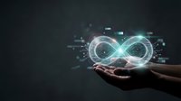 Hands holding glowing infinity symbol with digital particles and light effects on dark background representing endless possibilities and innovation.