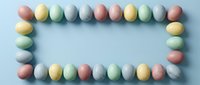 Pastel Easter eggs arranged in a rectangular frame on a light blue background, leaving copy space in the center for text or design.