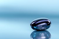 Sleek metallic oval capsule with iridescent blue and purple reflections on glossy surface against soft blue background with mirror reflection.