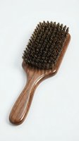 Natural bristle hairbrush with wooden handle for grooming, styling, and hair care routines on white background.