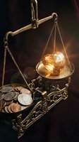 Vintage brass scales weighing golden heart-shaped gemstone against coins, symbolizing value of love versus money in warm atmospheric lighting.