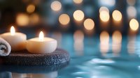 Glowing white candles on dark spa towel with blurred bokeh lights reflecting in water surface create tranquil wellness atmosphere for relaxation and meditation.