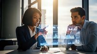 Professional African American businesswoman and Middle Eastern businessman analyzing holographic financial data charts in modern office meeting room.