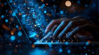 Female hands typing on laptop keyboard in dark room with magical glowing blue and orange bokeh light effects creating ethereal atmosphere for technology concept.