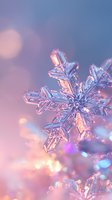 Crystalline snowflake macro with soft pink and blue bokeh background creates magical winter atmosphere. Delicate ice crystal structure catches light in dreamy holiday scene.