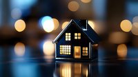 Glowing miniature house silhouette against blurred bokeh lights background creates cozy evening atmosphere, reflecting warmth and comfort for real estate concepts.
