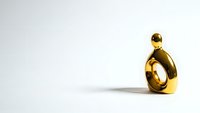 Golden abstract sculpture with curved organic form on white background for modern interior design and luxury decor concepts.