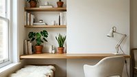 Wooden desk with floating shelves displaying potted plants, books, and decorative items near a bright window, featuring a desk lamp and comfortable chair for home office or study space.