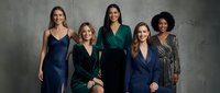 Five diverse professional women in elegant business attire posing confidently against concrete wall background for corporate team portrait photography.