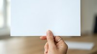 Person holding blank white card or paper in hand, suitable for business presentations, marketing mockups, advertising campaigns, and promotional materials.