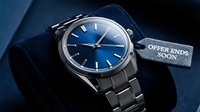 Elegant silver wristwatch with deep blue dial displayed on velvet stand with offer ends soon tag, luxury timepiece sale concept.