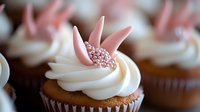Chocolate cupcake topped with swirled vanilla buttercream frosting and pink bunny ears decorated with sparkly sugar crystals, macro food photography.