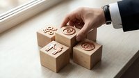 Businessman hand arranging wooden blocks with business icons including target, lightbulb, and growth symbols on office desk for strategic planning.
