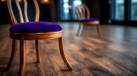 Elegant wooden chair with purple velvet cushion on hardwood floor in dimly lit restaurant interior, creating atmospheric dining ambiance.