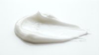Creamy white cosmetic product smear or skincare lotion sample isolated on white background, ready for beauty and wellness design applications.