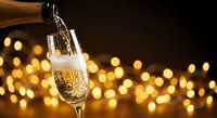 Champagne pouring into elegant flute glass with golden bokeh lights creating festive celebration atmosphere for New Year party events.
