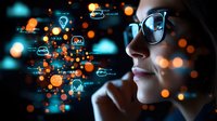Young woman with glasses looking at digital data visualization with glowing orange and blue icons reflecting on her face in dark environment.