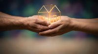 Protective hands holding glowing golden house outline symbol representing home security, real estate investment, property protection and family safety concept.