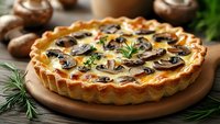 Homemade mushroom quiche with golden crust on wooden board, surrounded by fresh ingredients and herbs for gourmet cooking.