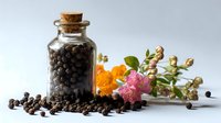 Black peppercorns in glass bottle with cork stopper alongside colorful dried flowers and herbs on white surface, ideal for culinary and wellness content.
