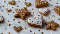 Festive gingerbread cookies with gold sprinkles and white icing in heart and star shapes on light background, perfect for holiday celebrations.