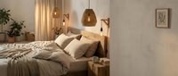 Cozy bedroom interior with warm lighting, wooden bed frame, beige bedding, pendant lamps, and minimalist decor for home design and lifestyle projects.