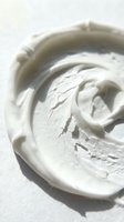 Overhead view of whipped cream or frosting swirled in a bowl with soft shadows, suitable for baking, dessert, and culinary content.
