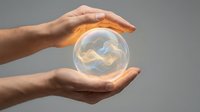 Protective hands surrounding glowing crystal sphere with swirling energy patterns symbolizing care, security, and spiritual protection concepts.