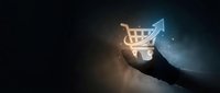Hand holding glowing shopping cart icon with upward arrow on dark background representing e-commerce growth and online retail success.