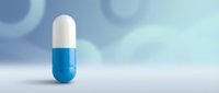 Blue and white pharmaceutical capsule pill on clean surface with soft lighting for medical healthcare and medication concepts.