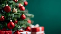 Festive Christmas tree with red ornaments and wrapped gifts against deep green background, creating elegant holiday atmosphere.
