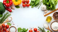 Fresh organic vegetables and herbs arranged as cooking ingredients frame on white background with copy space for culinary recipes and healthy meal preparation.
