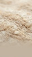 Soft beige wool yarn texture with natural fibers in warm neutral tones for crafting and textile projects.