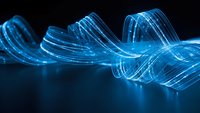 Glowing blue digital wave with flowing light trails and energy streams on dark background for technology and data visualization projects.