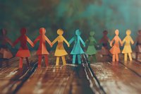 Paper cutout figures of women holding hands in rainbow colors on wooden surface, symbolizing unity, diversity, feminism and community support. Shallow depth of field.