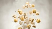 Fresh popcorn kernels flying and scattered in air against neutral background for snack food advertising and cinema entertainment concepts.